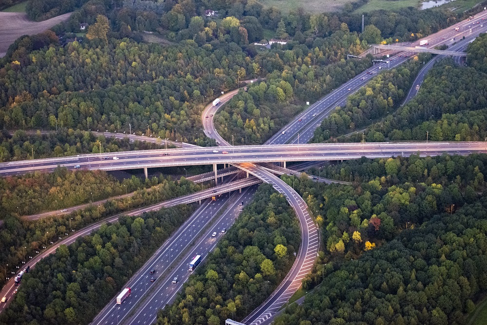 Sinuous curves of M25 motorway interchange at dusk, the street lights are on and cars are travelling along the 4 layer elevated jmajor road junction.