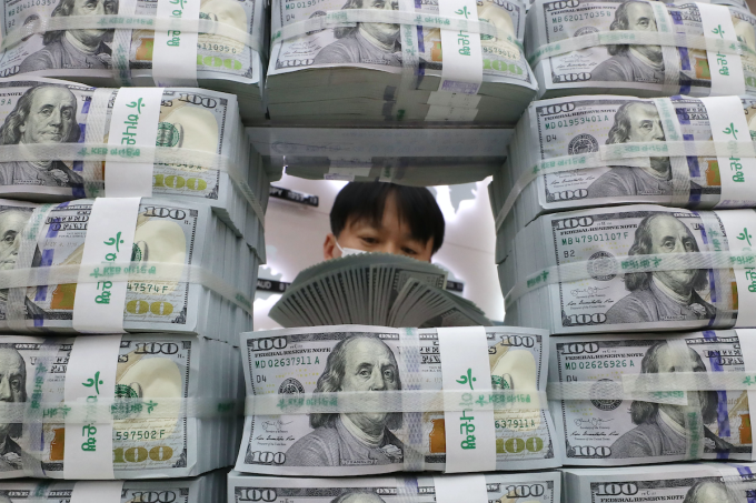 KEB　Hana　Bank　employee　examines　dollars　for　counterfeit　bills