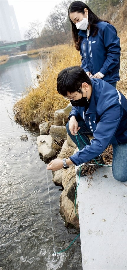 Samsung　Electronics’　Koo　Tae-wan,　a　senior　professional　in　the　environment　division,　collects　samples　from　Osan　stream　on　Jan.　3　for　water　quality　testing.　(Courtesy　of　Samsung　Electronics)