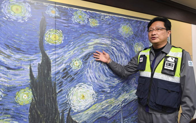 Dongkuk Steel Busan plant manager Joo Yong-joon shows steel plate etched with Van Gogh's The Starry Night.
