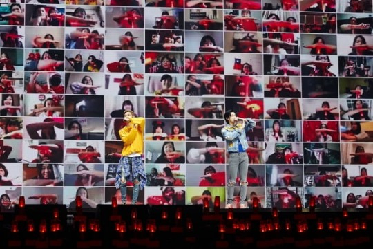 SM Entertainment duo TVXQ performs on stage while virtually interacting with fans.