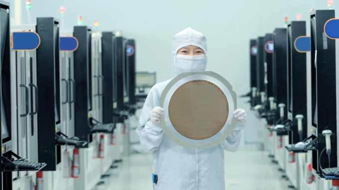 A　Samsung　Electronics　worker　holds　a　semiconductor　wafer.