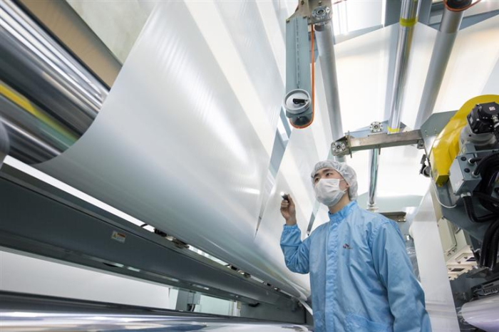 SK　IE　Technology　employee　examines　battery　separator　at　a　local　plant.