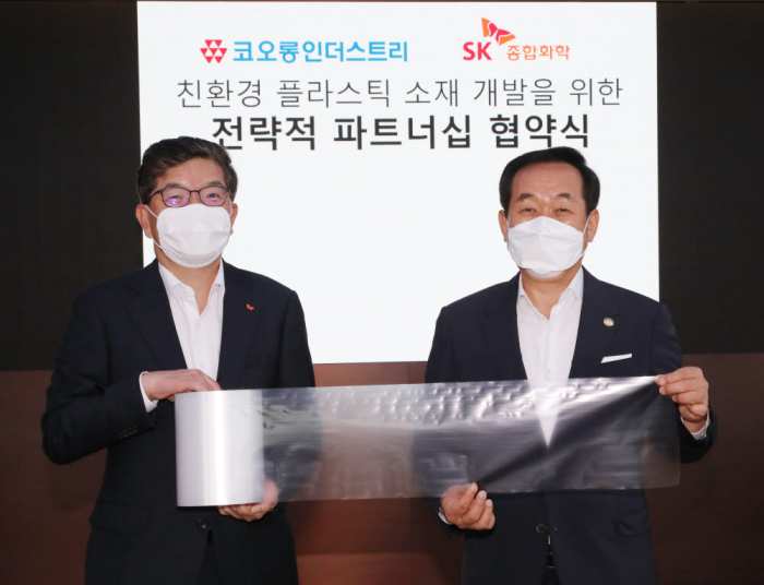 SK Global Chemical CEO Na Kyung-soo (left) and Kolon Industries CEO Jang Hee-goo (right) hold a PBAT sample at their strategic partnership signing ceremony. (Courtesy of SK Innovation)