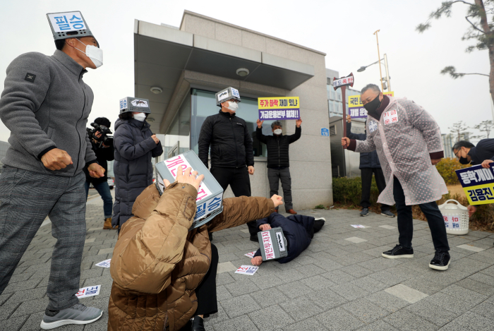 Individual　investors　stage　a　protest　performance　at　the　entrance　of　the　National　Pension　Service　headquarters　in　Jeonju　on　Mar.　4