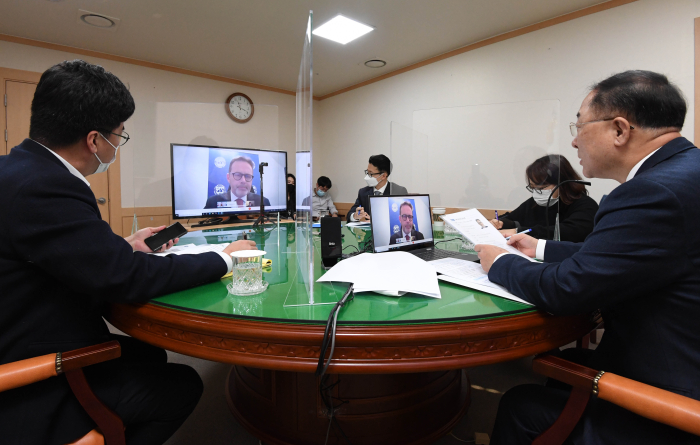 Finance Minister Hong Nam-ki (on right), IMF Korea mission chief Andreas Bauer (on screen) and Ahn Do-geol, second vice finance minister (on left) during a virtual conference in January 2021 after annual consultations