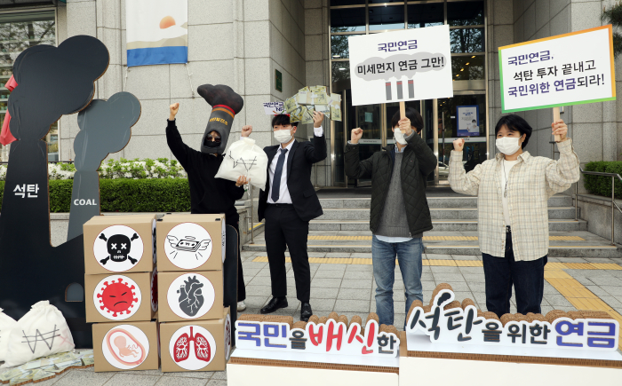 Environmental　activists　stage　a　performance　outside　a　Seoul　office　building　on　Apr.　20　to　protest　NPS　investment　in　coal-related　companies.