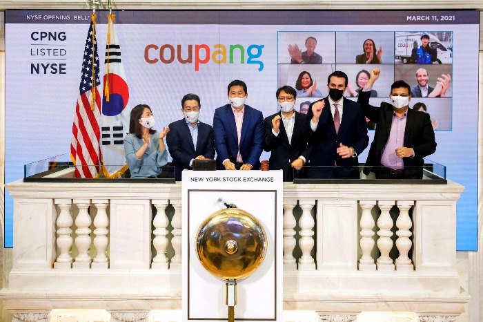 Coupang　executives,　including　founder　and　CEO　Kim　Bom-suk　(center),　and　New　York　Stock　Exchange　officials　celebrate　Coupang's　listing　on　Mar.　12