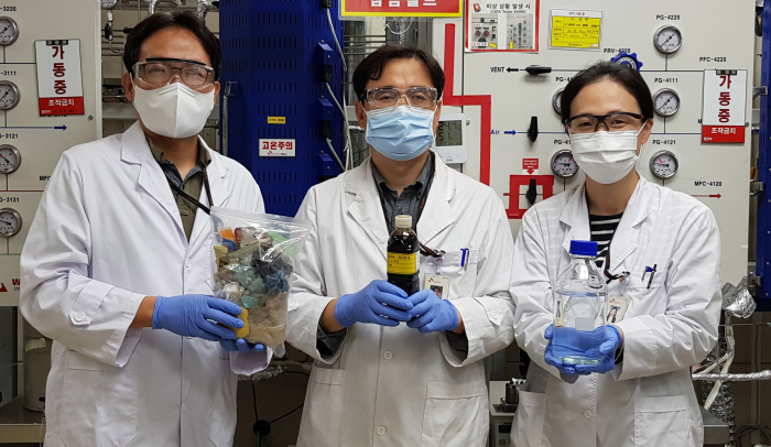 SK Innovation researchers hold samples of pyrolysis oil and insolvent made of waste plastic (Courtesy of SK Innovation)