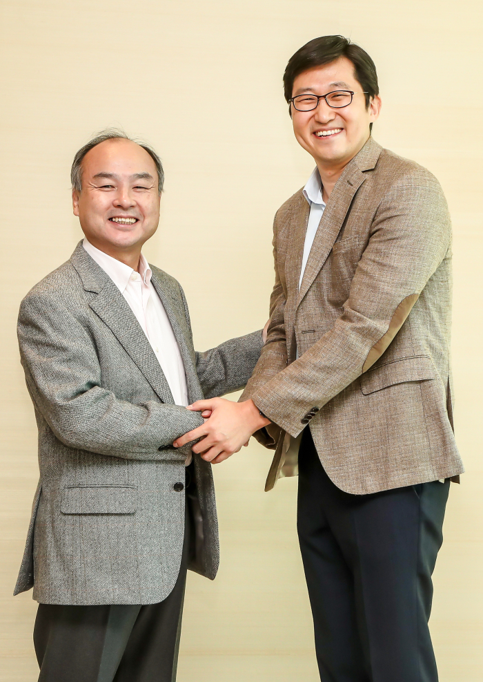 Masayoshi Son shakes hands with Coupang founder and CEO Kim Bom-suk in Dec. 2018 after Vision Fund announced a billion investment in the Korean e-commerce platform