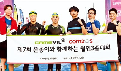 Gamevil,　Com2uS-sponsored　triathlon　in　2019.　Song　(third　from　left)　takes　a　photo　with　his　employees.　(Courtesy　of　Com2uS)