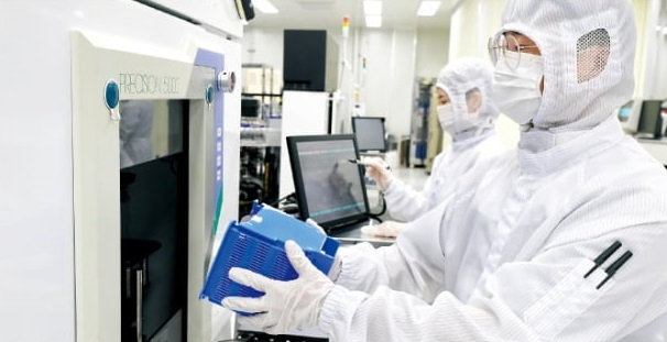 A Nanox employee at its Cheongju facility inserting a wafer into semiconductor equipment