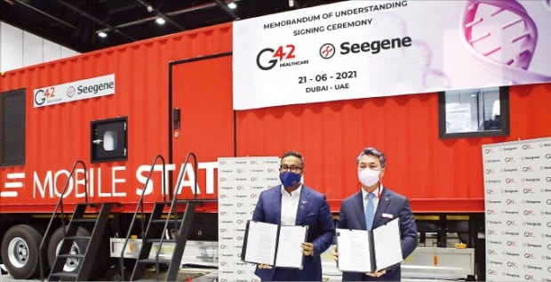 G42　Healthcare　CEO　Ashish　Koshy　(left)　and　Seegene　executive　director　James　Park　sign　an　MOU.