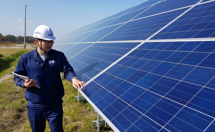 An LS Electric employee is inspecting solar panels at a solar farm in Chitose, Hokkaido