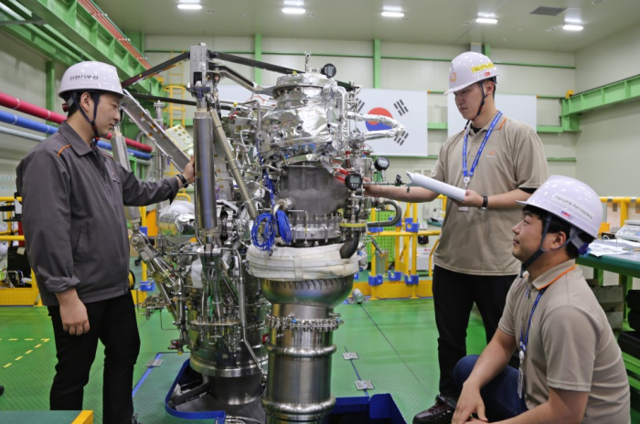 Hanwha　employees　with　a　satellite　thruster　prototype
