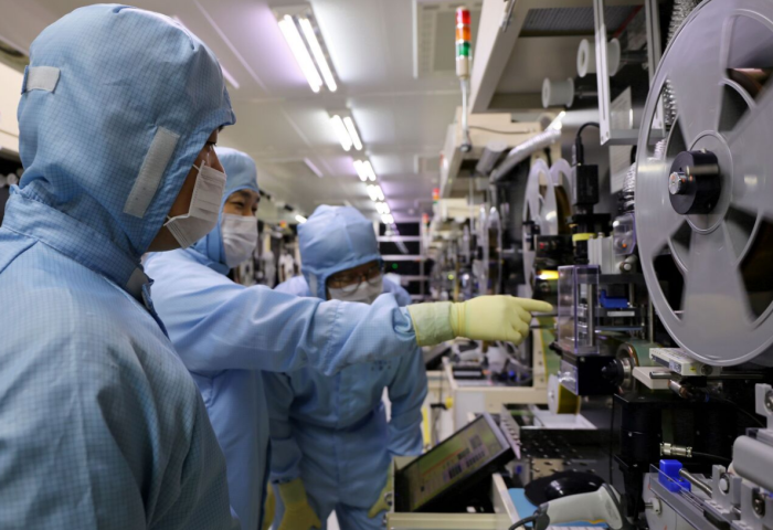 LG Innotek researchers examining the tape substrate inspection equipment (Courtesy of LG Innotek).