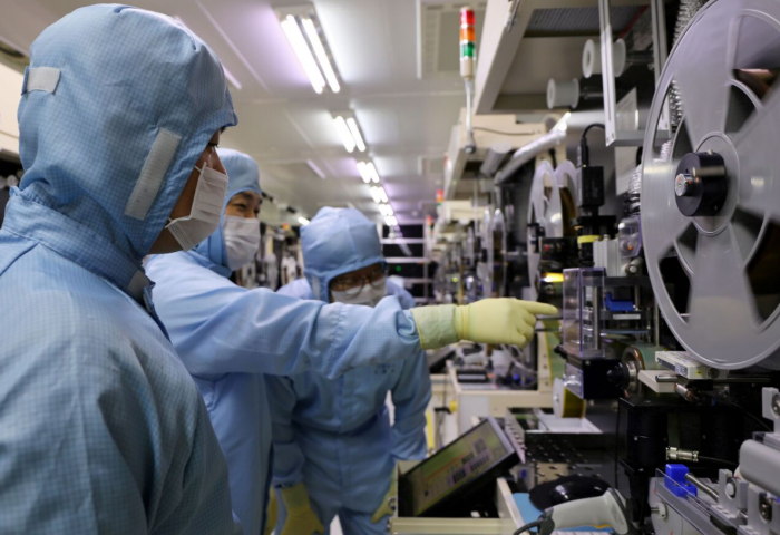 LG　Innotek　researchers　examining　the　tape　substrate　inspection　equipment　(Courtesy　of　LG　Innotek).