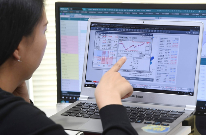 A　South　Korean　retail　investor　is　checking　foreign　stock　markets　with　her　personal　laptop.