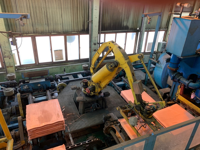 A robot is moving copper product.