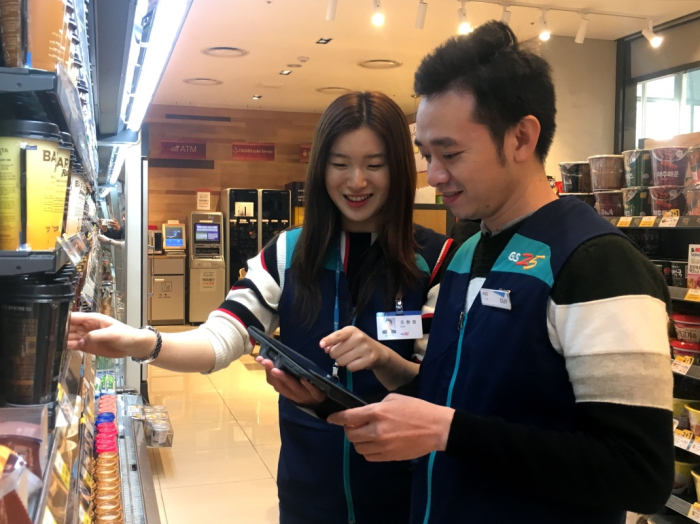 A　South　Korean　GS25　employee　trains　a　Vietnamese　employee