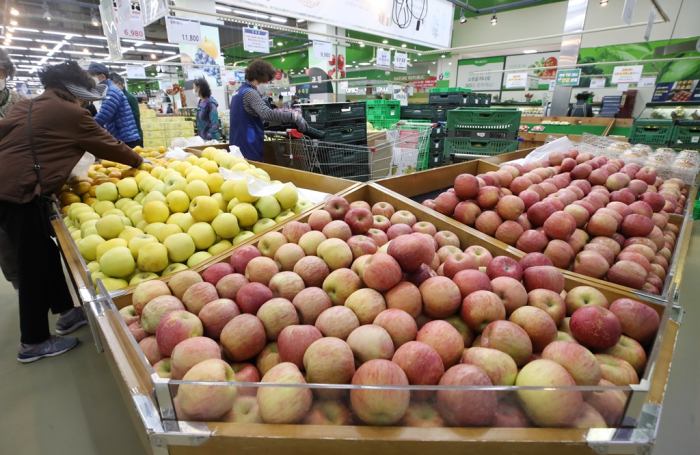 A　customer　examines　fruit　at　a　hypermarket　in　Seoul