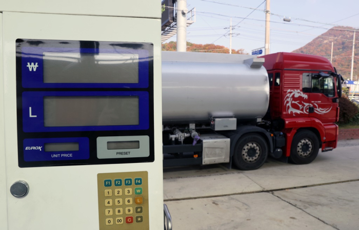 A　truck　stops　at　a　gas　station　in　South　Korea　to　replenish　diesel　exhaust　fluid,　but　a　lubricator　for　the　liquid　has　been　turned　off　due　to　the　supply　shortage