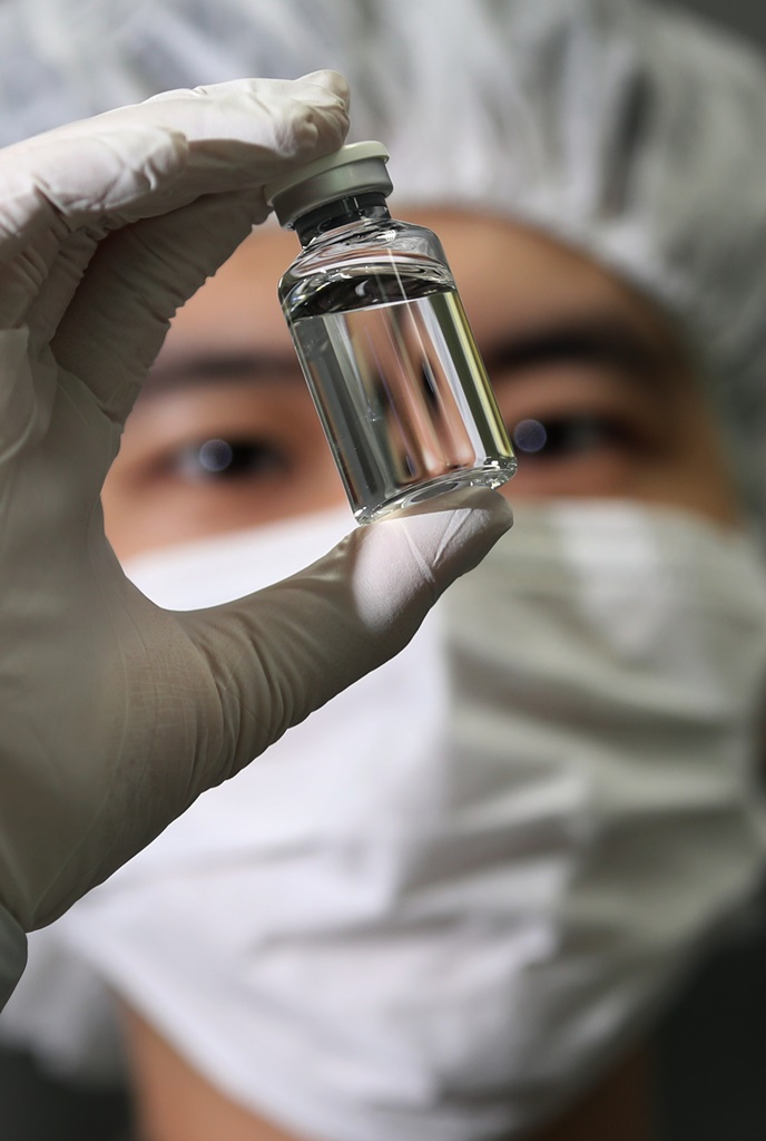 A Celltrion employee examines a vial of Regkirona