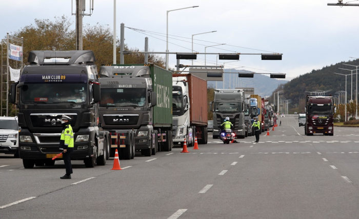 Cargo trucks line up to replenish diesel exhaust fluid at a gas station in South Korea