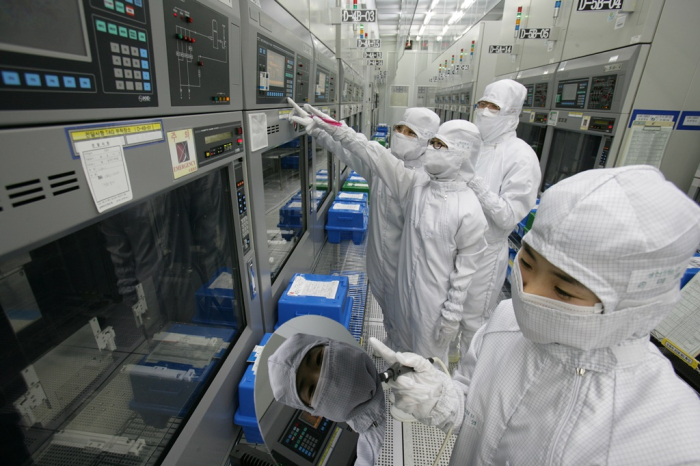 Magnachip Semiconductor employees inspect analog chip equipment at a plant in Gumi, South Korea