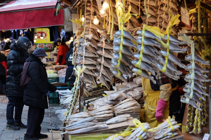 Customers　examine　fish　at　a　marketplace　in　Seoul.　Inflation　stubbornly　remained　around　a　10-year　high　in　December　of　2021. 