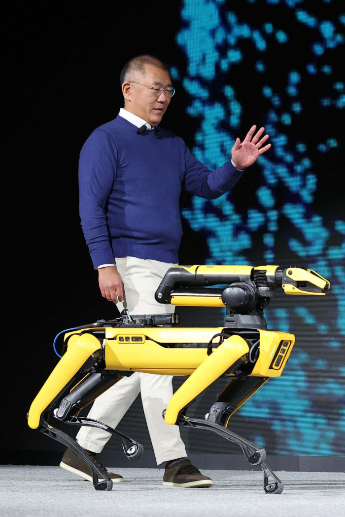 Hyundai Motor Group Chairman Chung Euisun walks onto the stage with the four-legged robot Spot of Boston Dynamics it acquired last year, during Hyundai Motor's press conference in Las Vegas in January 2022