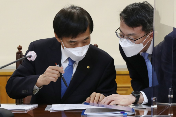 Bank of Korea Governor Lee Ju-yeol (left) checks papers during a meeting on the macroeconomy and financial markets on Feb. 11