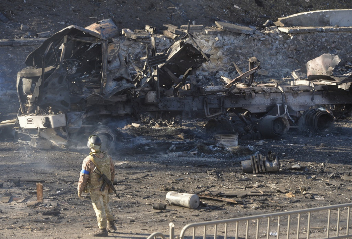 A Ukrainian serviceman stands near a charred vehicle after night fighting in Kiev, Ukraine, on Feb. 26. (Courtesy of EPA, Yonhap)
