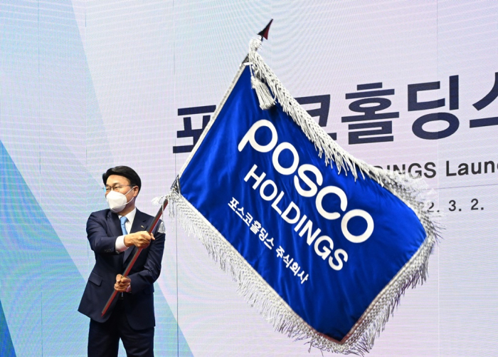 POSCO Group Chairman and Chief Executive Choi Jeong-woo waves a POSCO Holdings flag at the launch of the holding company on March 2.