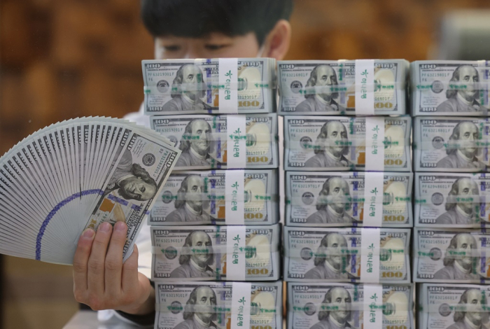 An　employee　fans　0　bills　at　South　Korea’s　Hana　Bank　headquarters
