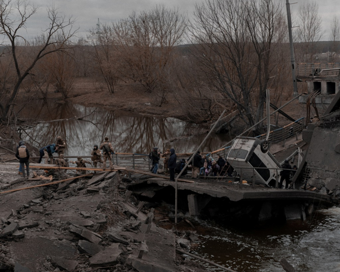 People　cross　a　makeshift　bridge　as　they　flee　the　city　of　Irpin　in　the　Kyiv　region,　Ukraine　on　March　5　(Courtesy　of　Reuters,　Yonhap)