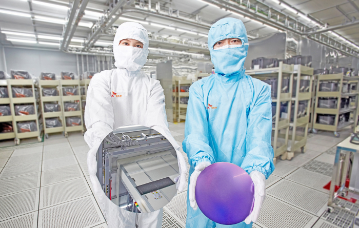 SK　Siltron　employees　display　silicon　wafers　produced　at　its　factory