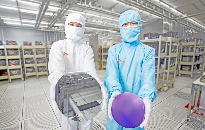 SK Siltron employees display silicon wafers produced at its factory