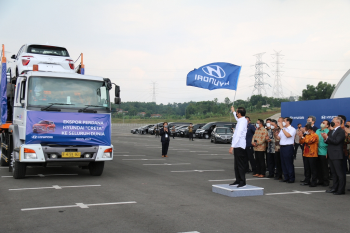 Indonesian President Joko Widodo waves a Hyundai flag at the automaker's Indonesian plant
