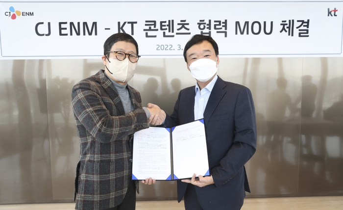 CJ　ENM　CEO　Kang　Ho-sung　(left)　and　KT　Studio　Genie　chief　Yoon　Kyung-lim　sign　a　content　cooperation　MOU