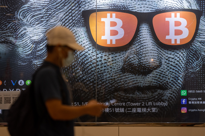 A　man　walks　by　an　ad　for　Bitcoin　in　Hong　Kong　in　2021