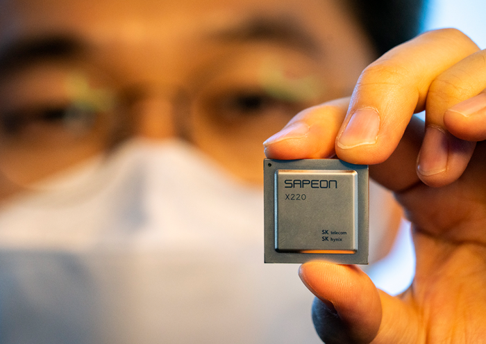 SK　Telecom　employee　holds　up　SAPEON　AI　chip　processor