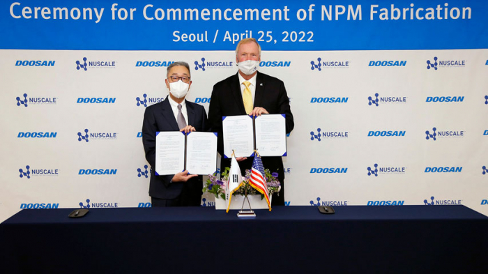 Doosan Enerbility CEO Park Geewon (left) and NuScale Power CEO John Hopkins (right) sign an equipment supply agreement at Doosan Tower