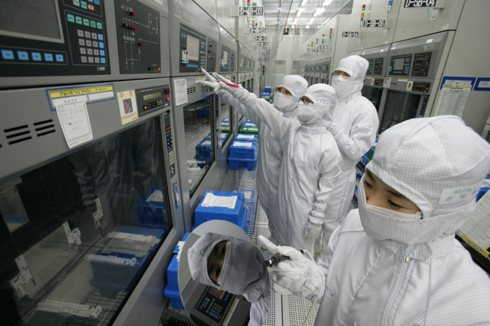 Magnachip Semiconductor employees inspect analog chip equipment