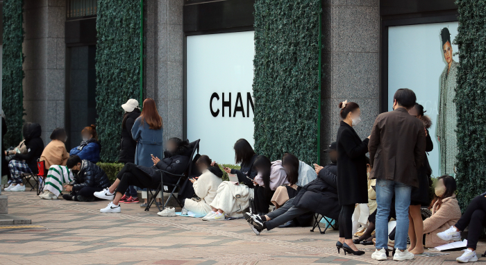 People line up in front of a Chanel boutique in downtown Seoul, November 2021