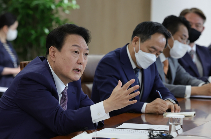 South　Korea's　new　President　Yoon　Suk-yeol　(left)　speaks　to　his　secretaries　on　May　11,　2022