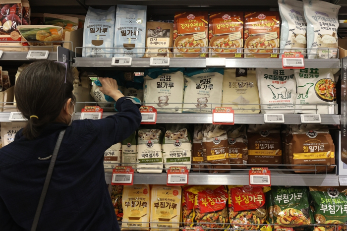 A　customer　picks　up　flour　at　a　hypermarket　in　Seoul　on　May　15,　2022,　as　its　prices　are　expected　to　rise　further　following　India's　ban　on　wheat　exports　(Courtesy　of　Yonhap)