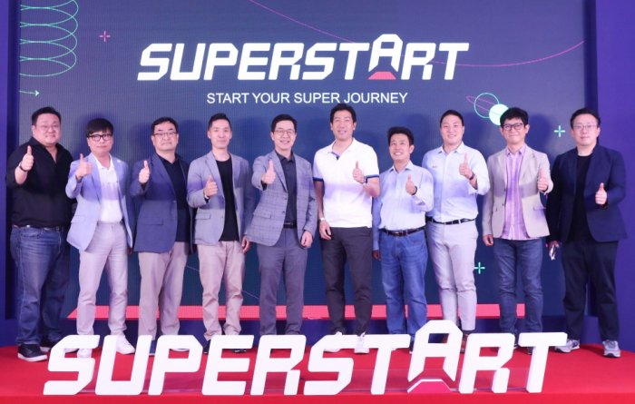 At　the　launch　event　of　LG　Group's　startup　accelerator　brand　Superstart,　LG　Sciencepark　President　I.P.　Park　(with　glasses　and　plaid　blazer　in　the　middle)　poses　with　his　team　for　the　camera