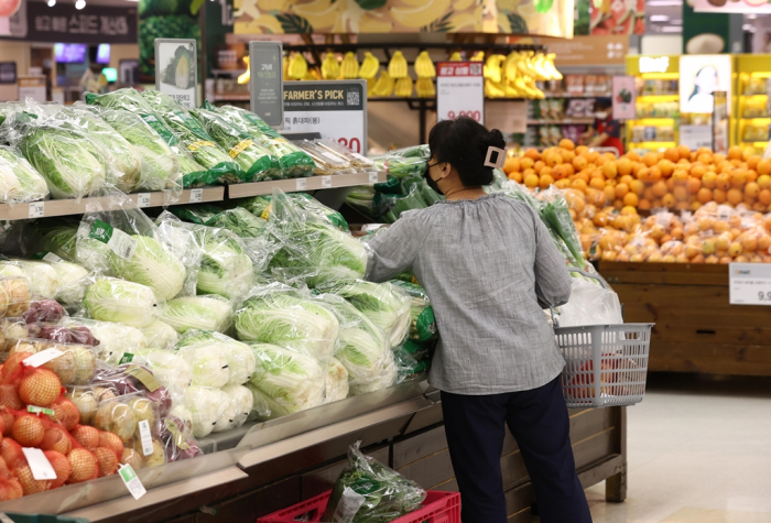 A　customer　examines　vegetables　at　a　hypermarket　in　Seoul
