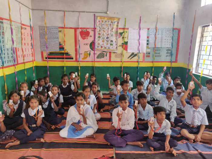 A group of students in India hold up their Class Saathi devices. Saathi means buddy in Hindi.